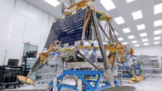 космический корабль в форме куба, покрытый золотой фольгой, установлен на тележке в белая чистая комната