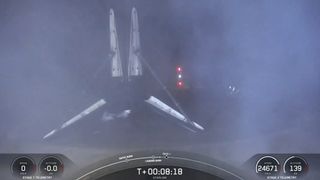 Черно-белая первая ступень ракеты SpaceX Falcon 9 на палубе корабля в море ночью