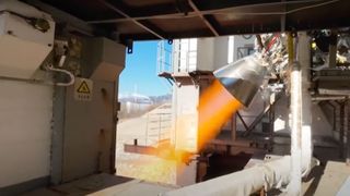 крупный план запуска ракетного двигателя, создающего полосу оранжевого пламени во время наземного испытания